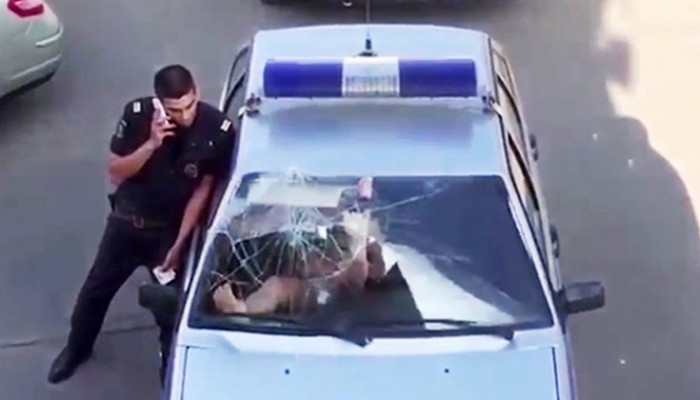 Γυναίκα σπάει με γυμνά πόδια το παρμπρίζ περιπολικού