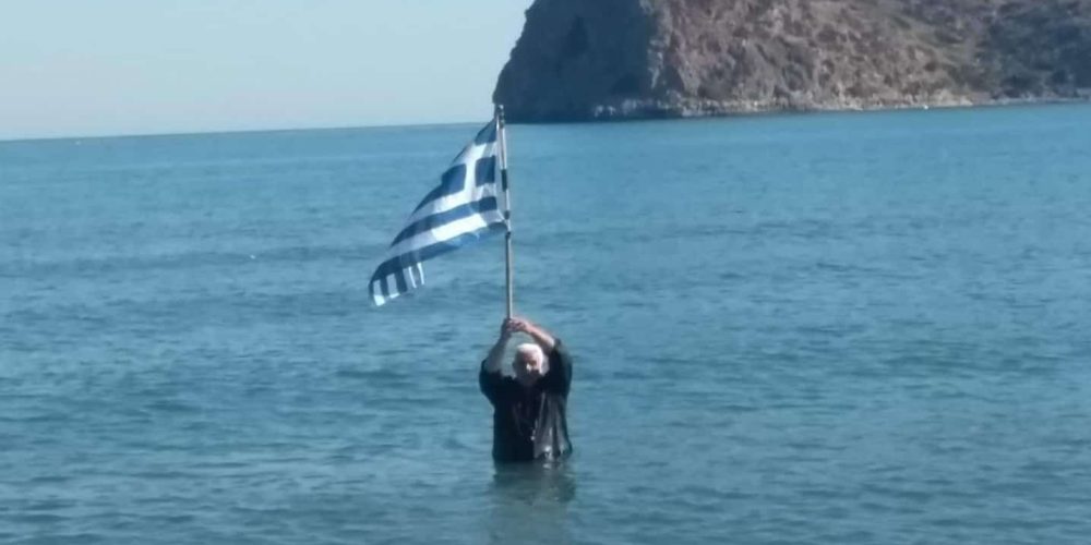 Γνωστός Χανιώτης βούτηξε με τα ρούχα στη θάλασσα και ύψωσε την Ελληνική σημαία