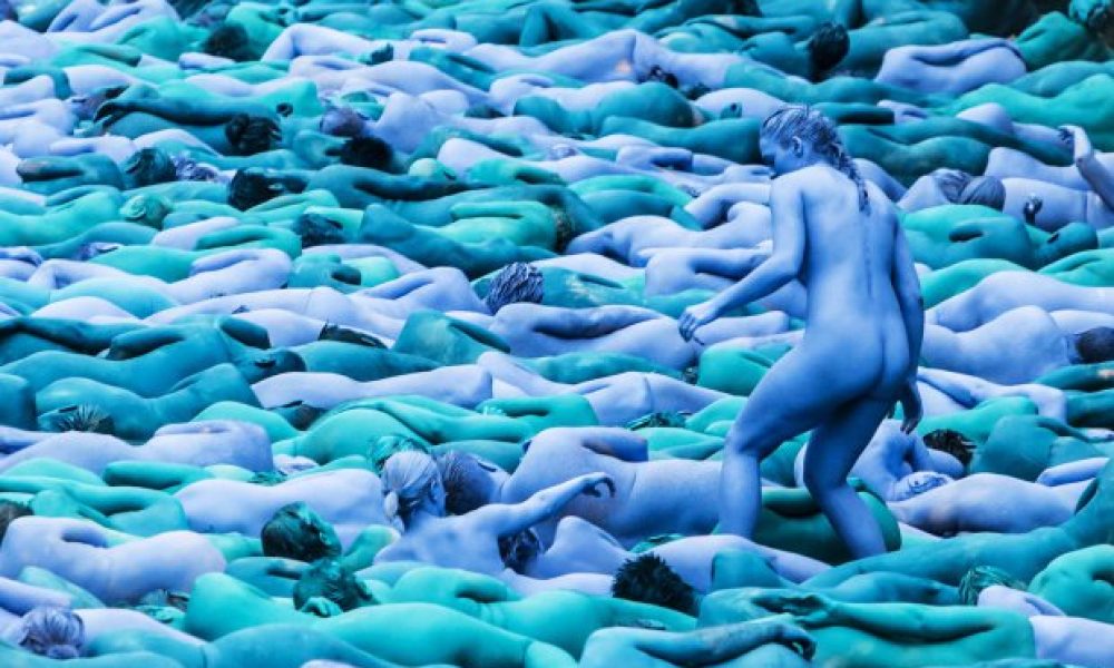 Πάνω από 3.000 εθελοντές από 20 χώρες γδύθηκαν και στη συνέχεια βάφτηκαν με τρεις διαφορετικές αποχρώσεις του μπλε στο πλαίσιο του νέου έργου του καλλιτέχνη Σπένσερ Τούνικ, ο οποίος ειδικεύεται σε μαζικά γυμνά έργα τέχνης.